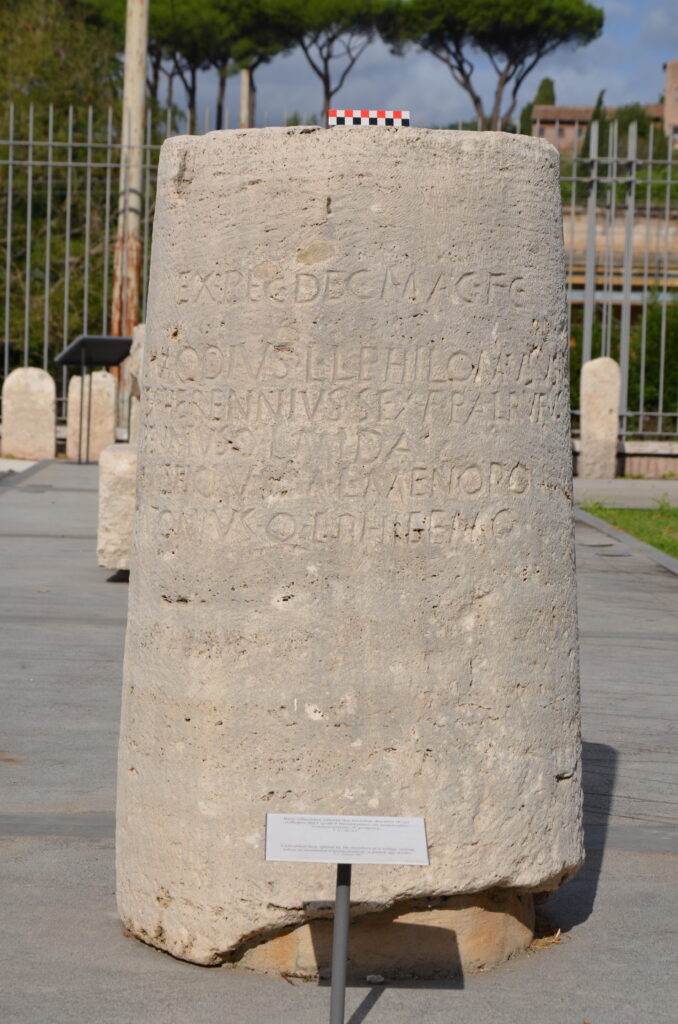 Base cilindrica in travertino con dono di cinque magistri